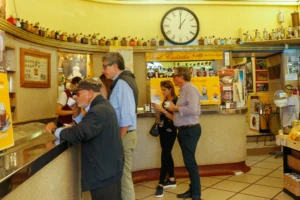 Clientes tomam café em pé ao balcão do histórico Sant'Eustachio Caffè em Roma